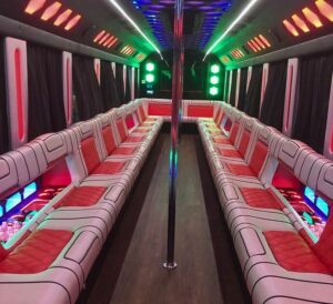 Spacious interior of a limo bus with leather seats and mood lighting.